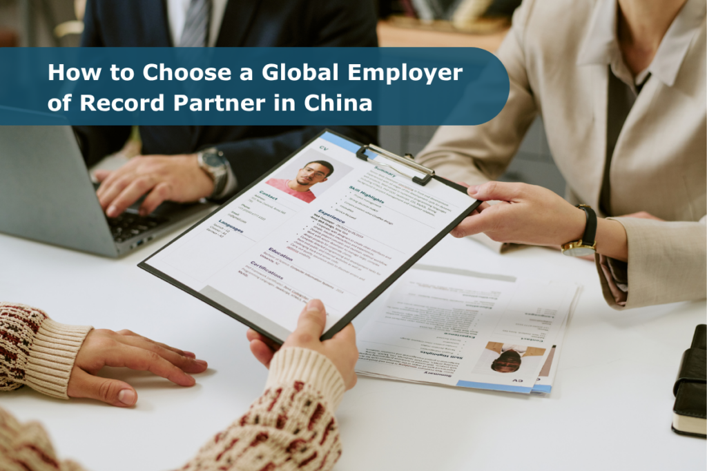 Business professionals reviewing candidate documents, illustrating how to choose a global employer-of-record partner in China for compliant, structured hiring.